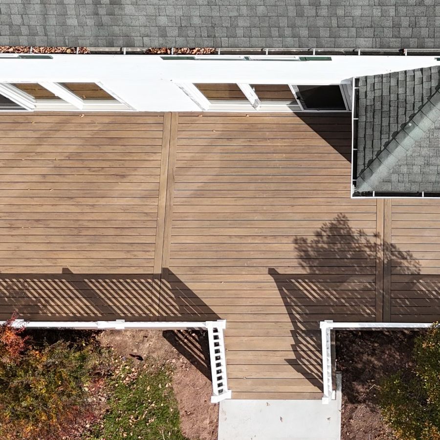 Drone view of the finished deck with white railings and main stairs to a concrete landing